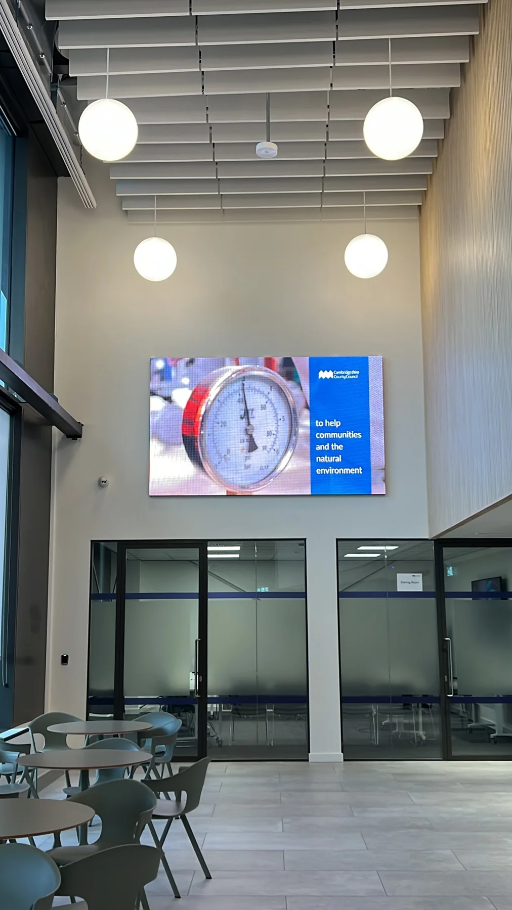 Large LED display above doors in a bright commercial atrium